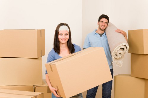Removal team carrying furniture down stairs in Stepney flat move